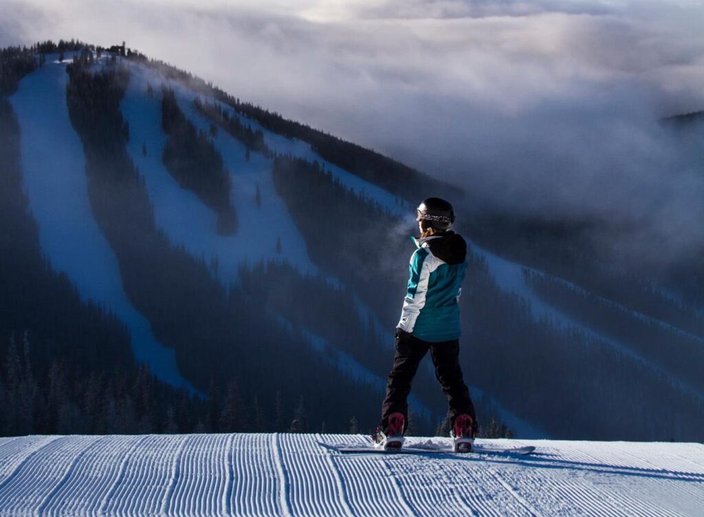 Snowboarder on top of Keystone mountain overlooking north peak
